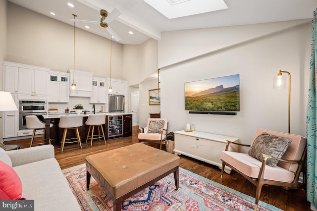 living room featuring beamed ceiling, dark hardwood / wood-style floors, beverage cooler, and a skylight