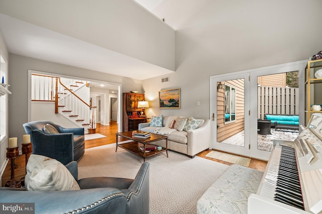 living room featuring a towering ceiling and light hardwood / wood-style flooring