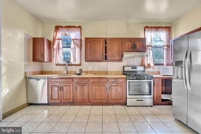 kitchen featuring plenty of natural light, sink, stainless steel appliances, and tasteful backsplash