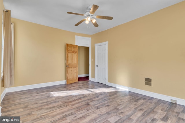 spare room featuring hardwood / wood-style floors and ceiling fan