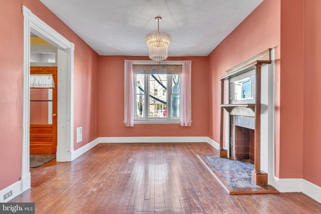 unfurnished living room with wood-type flooring and a chandelier