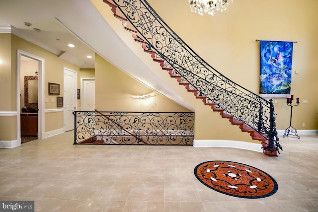 stairway featuring crown molding and a chandelier