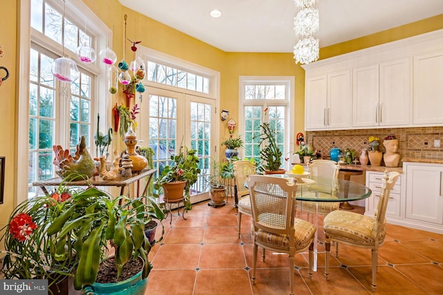 dining area featuring an inviting chandelier, french doors, and light tile patterned floors