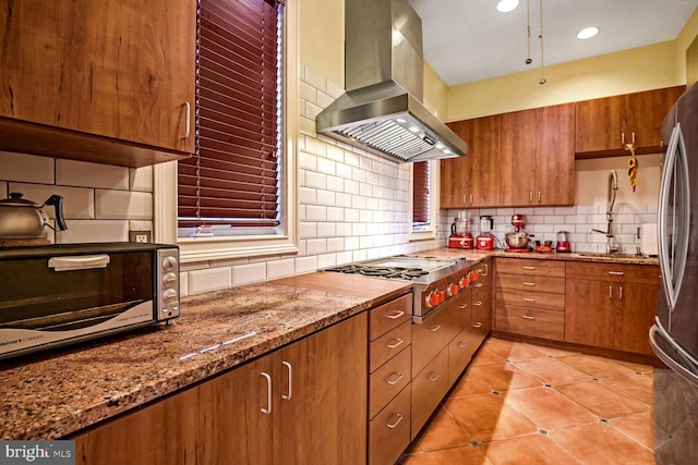 kitchen featuring sink, stainless steel appliances, island exhaust hood, light stone counters, and light tile patterned flooring