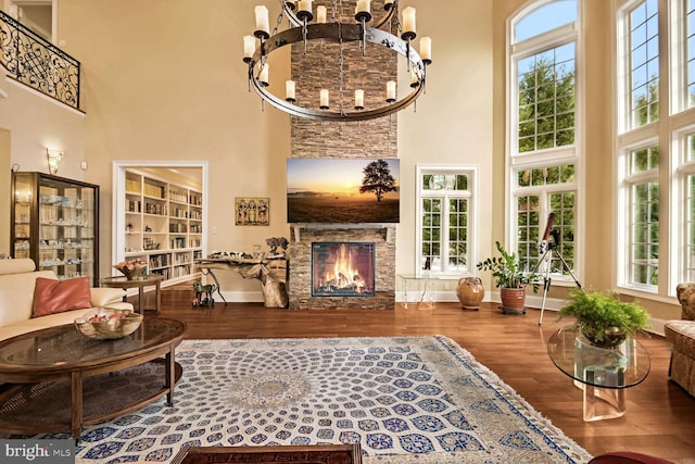 living room with plenty of natural light, a fireplace, hardwood / wood-style floors, and a high ceiling