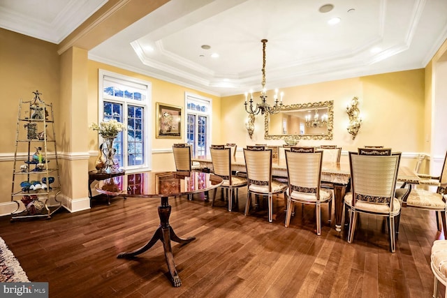 dining room featuring ornamental molding, dark hardwood / wood-style flooring, a raised ceiling, and a notable chandelier