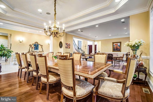 dining room with crown molding, a tray ceiling, and hardwood / wood-style floors