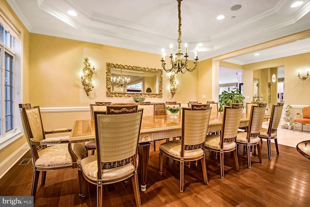 dining space featuring a tray ceiling, ornamental molding, and dark hardwood / wood-style floors