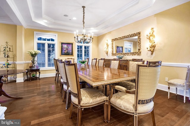 dining area featuring crown molding, dark hardwood / wood-style floors, an inviting chandelier, and a tray ceiling