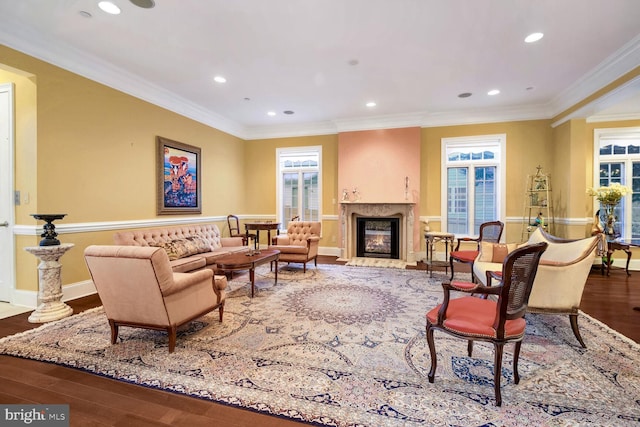 living room with wood-type flooring, a high end fireplace, and crown molding