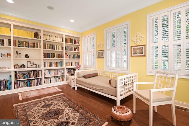 sitting room featuring wood-type flooring and ornamental molding