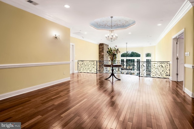 interior space with a notable chandelier, crown molding, and hardwood / wood-style flooring