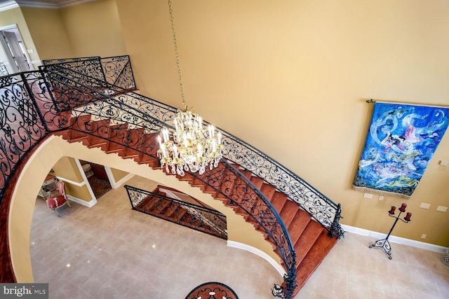 stairway with a towering ceiling, tile patterned flooring, and a notable chandelier