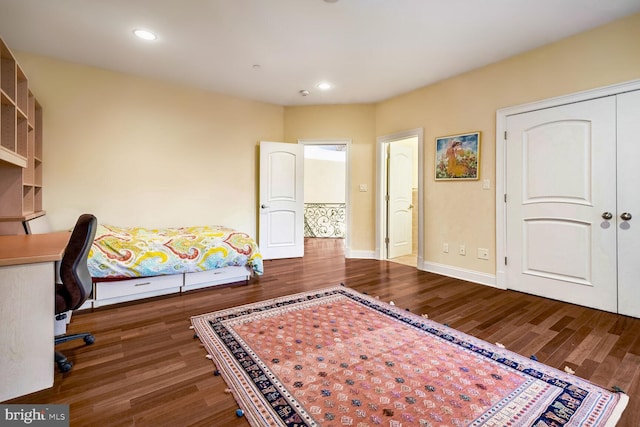 bedroom with dark hardwood / wood-style flooring