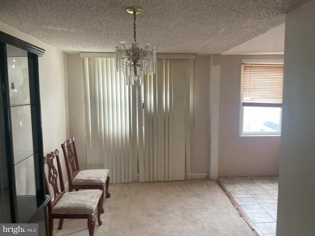 living area with a textured ceiling, a chandelier, and carpet flooring