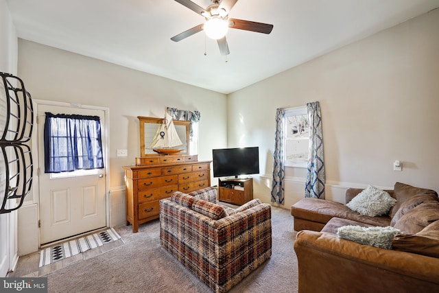 carpeted living room with ceiling fan