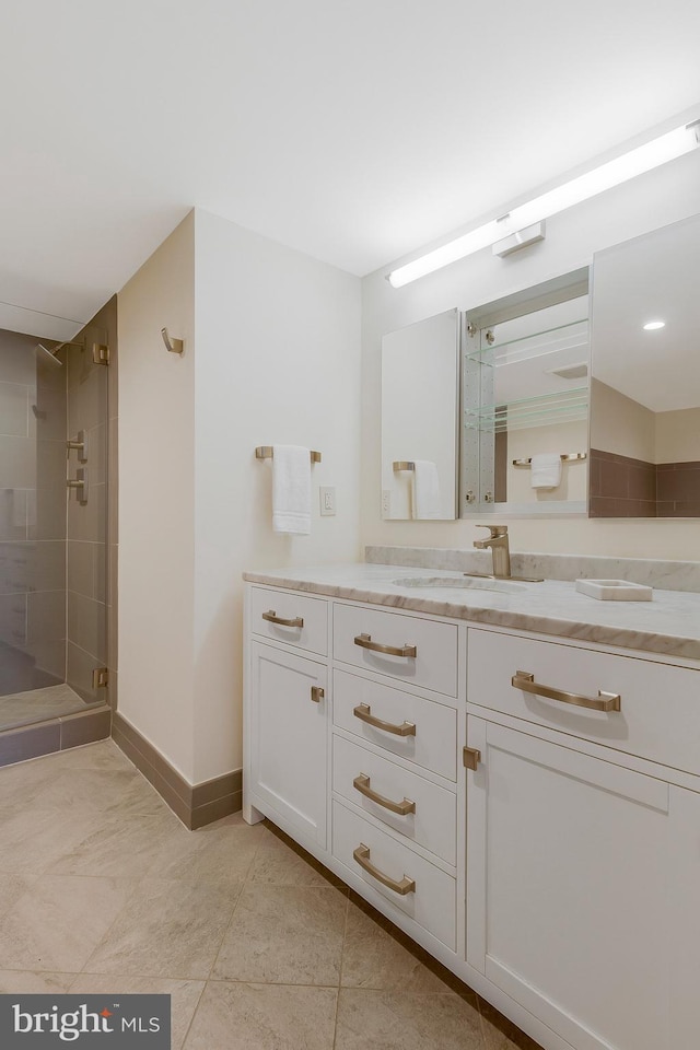 bathroom featuring a shower with shower door and vanity