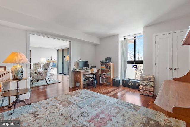 bedroom featuring a wall of windows, dark hardwood / wood-style floors, and a closet