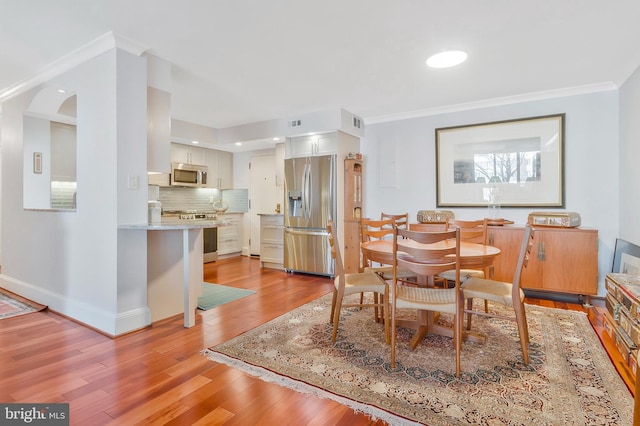 dining room featuring crown molding and light wood-type flooring