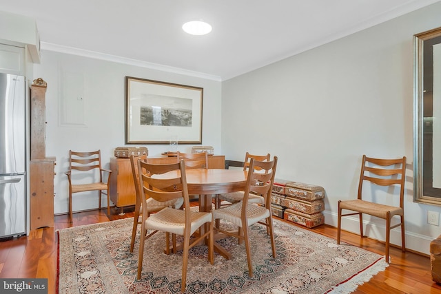 dining area featuring hardwood / wood-style floors and crown molding