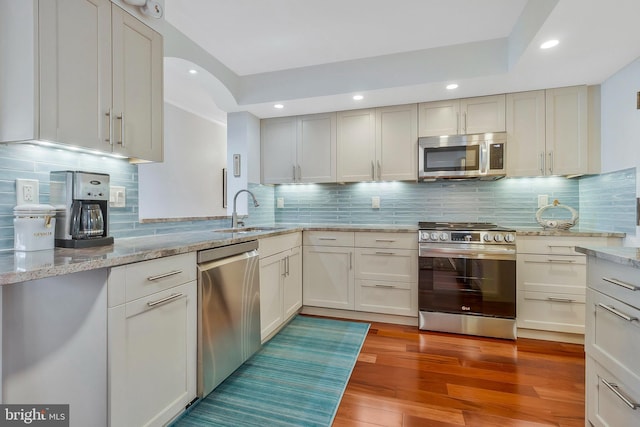 kitchen featuring light hardwood / wood-style floors, sink, stainless steel appliances, and tasteful backsplash