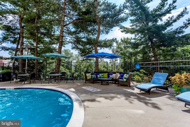 view of pool with an outdoor living space and a patio area