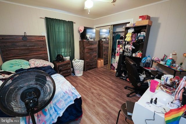 bedroom featuring ornamental molding, ceiling fan, light wood-type flooring, and a closet