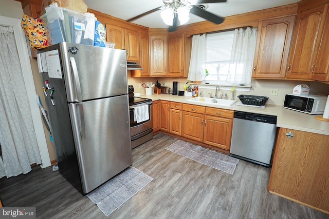 kitchen with sink, stainless steel appliances, ceiling fan, and light wood-type flooring