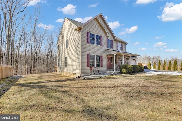 traditional home with covered porch, a front lawn, and fence