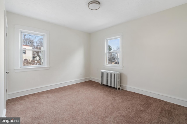 unfurnished room featuring radiator heating unit and carpet flooring