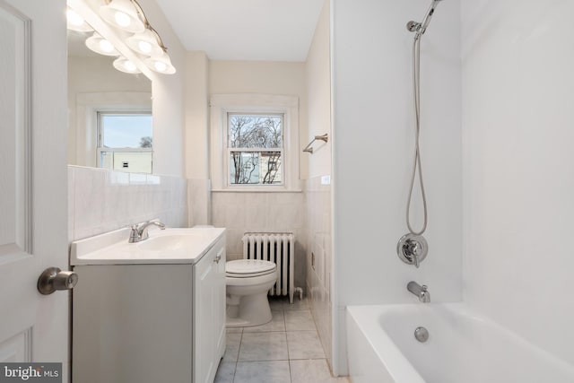 full bathroom with toilet, vanity, tile walls, radiator, and shower / tub combination