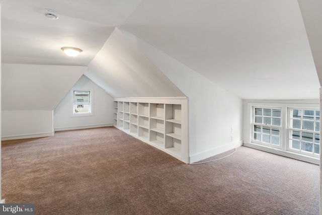 bonus room featuring lofted ceiling, carpet floors, and built in shelves