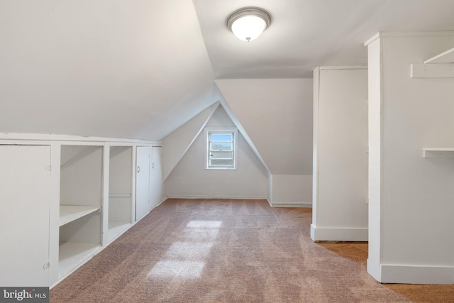 bonus room with light carpet and lofted ceiling