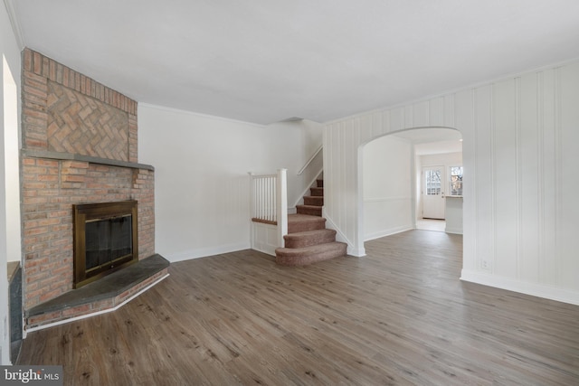 unfurnished living room featuring ornamental molding, a fireplace, and hardwood / wood-style flooring