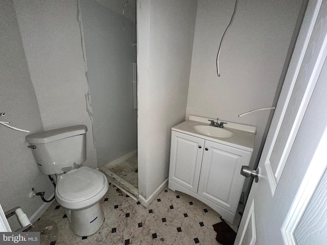 bathroom featuring toilet, vanity, and walk in shower