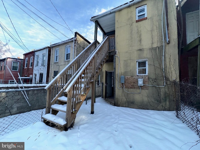 view of snow covered back of property