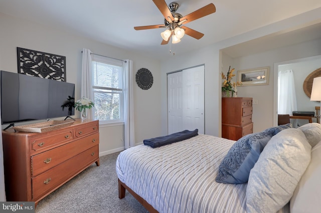 carpeted bedroom featuring ceiling fan and a closet