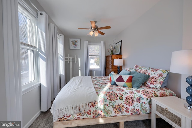 bedroom with ceiling fan, multiple windows, and carpet flooring