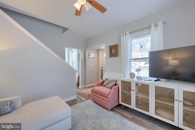 living room with ceiling fan and dark wood-type flooring