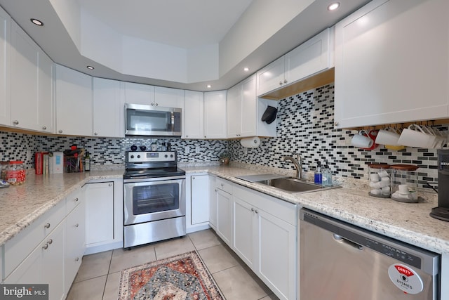 kitchen with appliances with stainless steel finishes, decorative backsplash, and white cabinetry