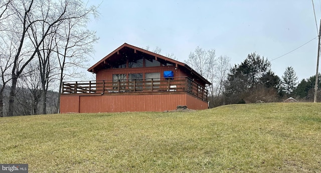 view of side of property featuring a deck and a yard