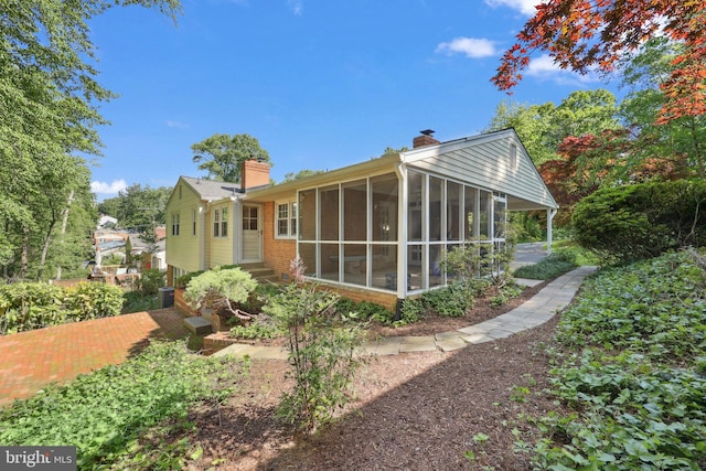 1113 Cameron Rd, Alexandria, VA 22308 - back of house featuring a chimney, a sunroom, and brick siding