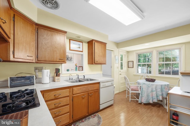 1113 Cameron Rd, Alexandria, VA 22308 - kitchen with white dishwasher, a sink, light countertops, black gas stovetop, and light wood-type flooring