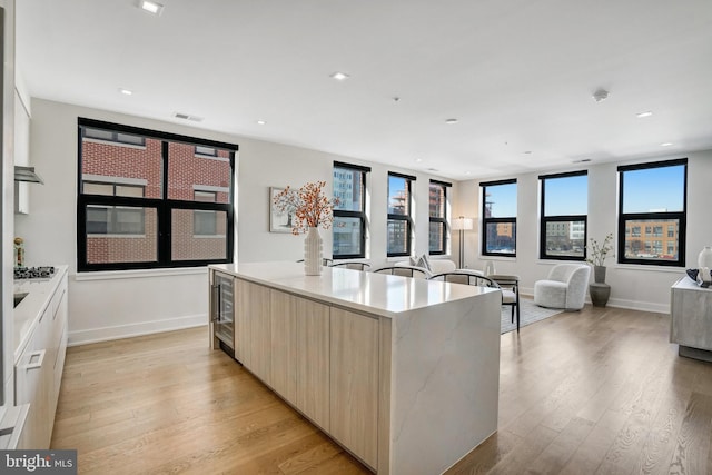 kitchen featuring light brown cabinetry, a center island, and light hardwood / wood-style floors