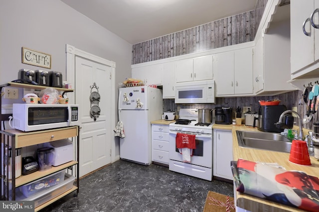 kitchen with sink, white appliances, white cabinets, and tasteful backsplash