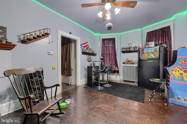 sitting room with ceiling fan, radiator, and dark hardwood / wood-style flooring