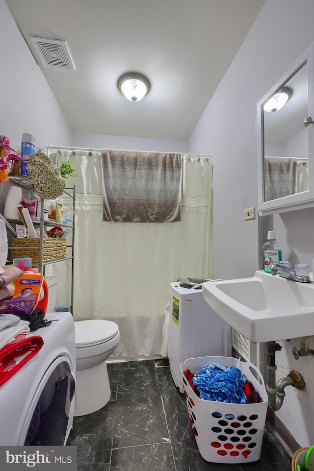 full bathroom featuring sink, toilet, shower / bathtub combination with curtain, and washer / clothes dryer