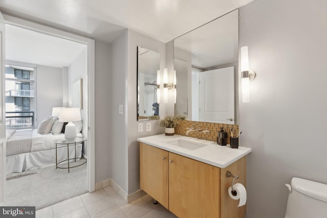 bathroom featuring decorative backsplash, tile patterned floors, vanity, and toilet