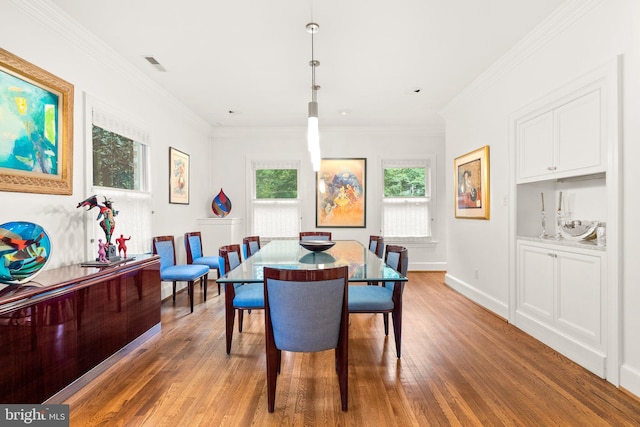 dining space with crown molding and hardwood / wood-style flooring