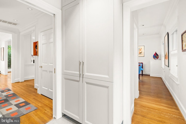 corridor with crown molding and light hardwood / wood-style floors